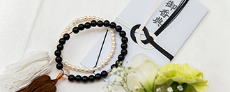 一般的な仏式の弔事に使用される男女の数珠と、弔意を表すためにやりとりされるお香典に用いられる香典袋