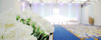 社葬・お別れの会の会場に設営された中型の祭壇と献花用のカーネーション